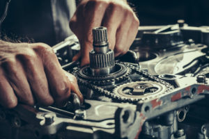 a closeup of two hands repairing a CVT gearbox
